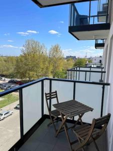 a balcony with two chairs and a table on a balcony at Apartament Letnica in Gdańsk