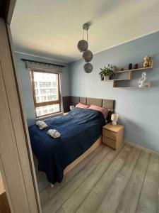 a bedroom with a blue bed and a window at Apartament Letnica in Gdańsk