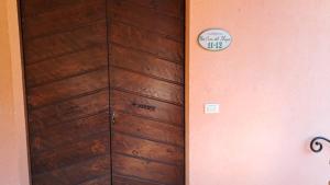 una porta in legno in una stanza con un cartello sul muro di Antico Borghetto - Casa Vacanze a Norcia