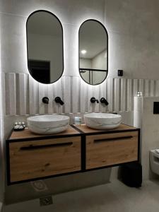 a bathroom with two sinks and two mirrors at Casa Benita in Hvar