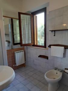 Łazienka z białą toaletą i umywalką w obiekcie Antico Borghetto - Casa Vacanze w mieście Nursja