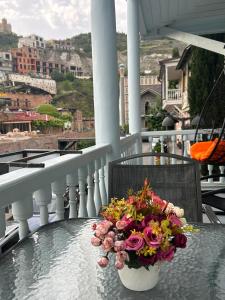 un vaso di fiori seduto su un tavolo sul balcone di Apartment in historical district of Tbilisi a Tbilisi City
