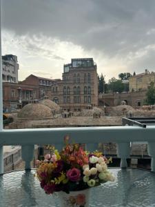 un mazzo di fiori in un vaso sul balcone di Apartment in historical district of Tbilisi a Tbilisi City