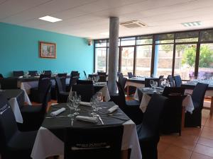 - une salle à manger avec des tables, des chaises et des fenêtres dans l'établissement Hotel Restaurante Comendador Añon de Moncayo, à Añón
