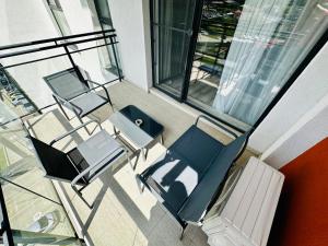 ティミショアラにあるSunset View Apartmentの建物内の空のバルコニー(椅子、テーブル付)