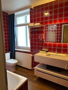 a bathroom with a toilet and a sink and a tub at hotel whiteswan in Ehnen
