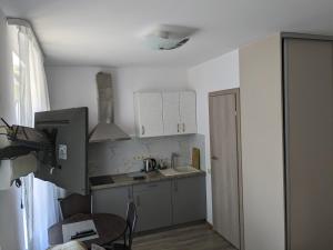 uma pequena cozinha com armários brancos e uma mesa em Sea of ​​Nida em Nida