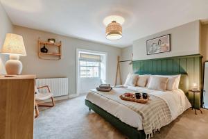 una camera con un grande letto con testiera verde di Molls Yard a Chipping Norton