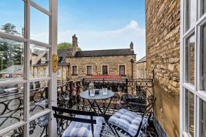a balcony with a table and chairs and a building at Molls Yard in Chipping Norton