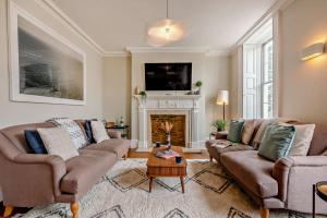 a living room with two couches and a fireplace at Molls Yard in Chipping Norton