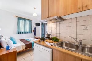 a kitchen with a sink and a bed in a room at Nikoleta Studio 2 in Nikiana