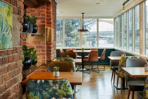 a restaurant with tables and chairs and a brick wall at Manchester Marriott Victoria & Albert Hotel in Manchester