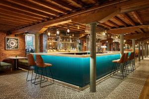 a blue bar with stools in a room at Manchester Marriott Victoria & Albert Hotel in Manchester