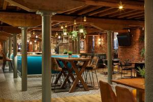 a room with tables and chairs and a pool at Manchester Marriott Victoria & Albert Hotel in Manchester