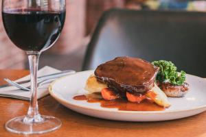 a plate of food and a glass of wine on a table at Manchester Marriott Victoria & Albert Hotel in Manchester