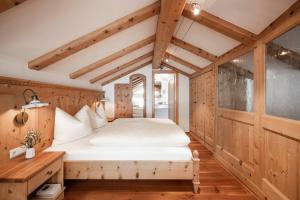 ein Schlafzimmer mit einem weißen Bett in einem Zimmer mit Holzwänden in der Unterkunft Radhof in Villanders