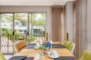 a dining room with a table and chairs and a large window at Mercure Johannesburg Midrand in Midrand