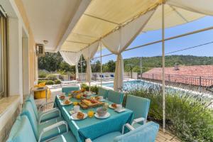 a patio with a table and chairs and a pool at Kika's Home in Križišće
