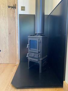 a kitchen with a stove with a tv in it at The Black Swan Shepherd Hut in Ketton