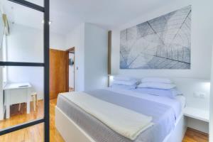 a white bedroom with a large bed with blue pillows at Kika's Home in Križišće +84 photos