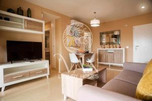sala de estar con sofá y TV de pantalla plana en Casa Lucero Ivan Luxury Homes 6ªPta Sur 1ªLinea, en Oropesa del Mar