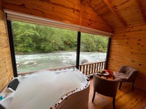 bañera en una habitación con vistas al río en Teona Bungalow & Restaurant, en Çiğil