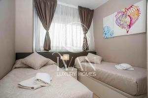1 dormitorio con 2 camas y ventana en Casa Hilario Ivan Luxury Homes 6ª Sur 1ªLinea, en Oropesa del Mar