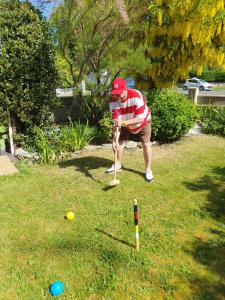 een man speelt met een teeball in het gras bij Cleave Court Guest House in Llandudno