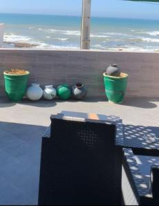 un gruppo di vasi verdi e bianchi seduti su un muro di Beachfront Villa Darbouazza a Dar Bouazza