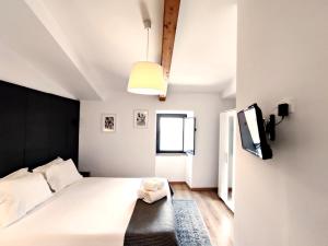 a bedroom with a bed and a tv on the wall at Arriaga Douro House in Peso da Régua