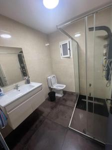 a bathroom with a toilet and a sink and a shower at Beachfront Villa Darbouazza in Dar Bouazza