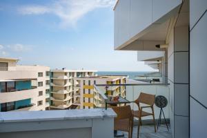 a balcony with chairs and a table on a building at Royale Sundance 224 Infinity Beach Pool & Spa Mamaia Nord in Mamaia Nord