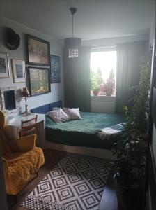 ein Schlafzimmer mit einem grünen Bett und einem Fenster in der Unterkunft Atrakcyjny apartament z dużym ogrodem in Danzig