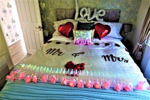 Una cama con un montón de rosas rosas. en Lakeland Lodge with private Hot Tub and fishing, en Hatfield Peverel