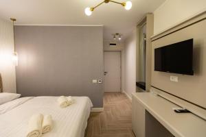 a hotel room with two towels on a bed and a television at DelSool MAMAiA-Boutique HOTEL in Mamaia