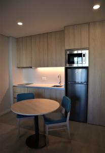 a kitchen with a table and chairs and a refrigerator at MEU STUDIO in Gandra +31 photos