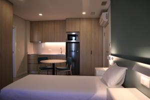 a small room with a bed and a small kitchen at MEU STUDIO in Gandra