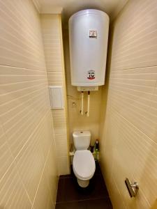 a small bathroom with a toilet and a water tank at Квартира на Воскресенці, поруч метро Лівобережна, Інститут Серця, МВЦ in Kyiv
