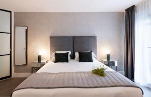 a bedroom with a large white bed with two lamps at Oxford Street Fitzrovia Apartments in London