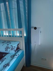 una camera con letto e finestra con tende blu di Zimmer "Türkis" a Lahr-Dinglingen