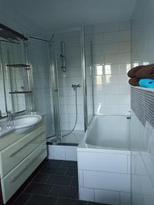 y baño con bañera, lavamanos y ducha. en Zimmer "Türkis", en Lahr-Dinglingen