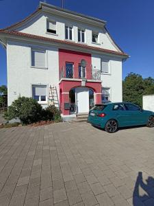 a blue car parked in front of a house at Zimmer "Türkis" in Lahr-Dinglingen