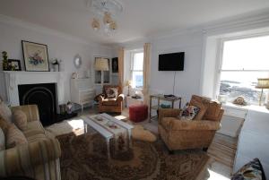 a living room with a couch and chairs and a fireplace at Westshore House- fabulous waterfront home Fife in Pittenweem