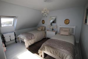 a bedroom with two beds and a chandelier at Westshore House- fabulous waterfront home Fife in Pittenweem