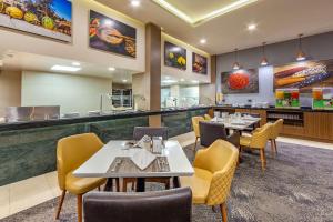 a restaurant with tables and chairs and a bar at Quality Inn Chihuahua San Francisco in Chihuahua