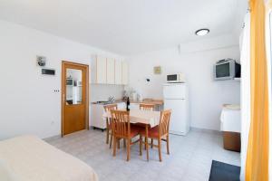 cocina y comedor con mesa y sillas en Apartments Veve, en Postira