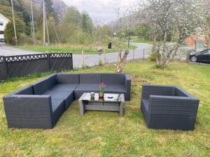 two couches and a table in the grass at Løkka,Summer cabin! in Åna-Sira