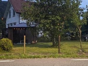 ein Hund, der im Gras vor einem Haus liegt in der Unterkunft Løkka,Summer cabin! in Åna-Sira