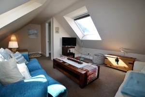 uma sala de estar com um sofá azul e uma mesa em Turnstone- beautiful coastal home Pittenweem em Pittenweem