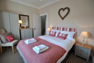 een slaapkamer met een groot bed met rode en witte kussens bij Turnstone- beautiful coastal home Pittenweem in Pittenweem +17 foto's